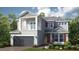 Charming two-story home with a balcony, gray siding, a gray shingle roof, and a well-kept landscaped yard at 1678 Trailhead Ln, Zephyrhills, FL 33541