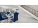 Dining area with a glass table, blue chairs, and modern staircase at 1712 Azalea Ct # A, Oldsmar, FL 34677