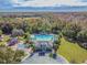 Aerial view of the community amenities, showcasing the pool, playground, clubhouse, and surrounding lush greenery at 17914 Howsmoor Pl, Lutz, FL 33559
