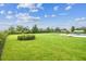 Wide angle view of the expansive backyard featuring a well-maintained lawn, bordered by lush greenery at 17914 Howsmoor Pl, Lutz, FL 33559