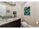 Bathroom featuring granite countertop, dark cabinets, and neutral decor at 17914 Howsmoor Pl, Lutz, FL 33559