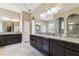 A spacious bathroom with a double vanity, granite counters, and a walk-in shower for a spa-like experience at 17914 Howsmoor Pl, Lutz, FL 33559