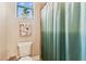 This bathroom has a shower/tub and toilet with decorative art on the walls at 17914 Howsmoor Pl, Lutz, FL 33559
