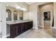 Bathroom with double vanity, granite countertop, walk-in closet, and a separate water closet for added privacy at 17914 Howsmoor Pl, Lutz, FL 33559