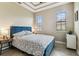 Comfortable bedroom with a stylish blue headboard, side tables, and plenty of natural light at 17914 Howsmoor Pl, Lutz, FL 33559