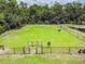 Aerial view of a fenced dog park with agility equipment, benches, and green space for pets to roam at 17914 Howsmoor Pl, Lutz, FL 33559