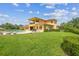 Exterior view of the expansive home and pool with lush green lawn, lounge chairs, and manicured hedges at 17914 Howsmoor Pl, Lutz, FL 33559