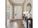 Warm foyer includes a table with decorative items, and access to an office with glass doors at 17914 Howsmoor Pl, Lutz, FL 33559