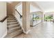 Bright foyer with staircase and open view into the living room at 17914 Howsmoor Pl, Lutz, FL 33559