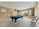 Bright game room featuring a pool table, neutral carpet, and a sliding glass door to the outdoor balcony at 17914 Howsmoor Pl, Lutz, FL 33559