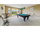 Spacious game room features a pool table and a large window with a picturesque view at 17914 Howsmoor Pl, Lutz, FL 33559