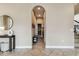 Hallway with arched doorway and tile floors leads to a staircase at 17914 Howsmoor Pl, Lutz, FL 33559