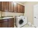 A well-organized laundry room with a washer, dryer, storage cabinets, and a sink area for convenience and efficiency at 17914 Howsmoor Pl, Lutz, FL 33559