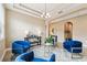 Staged living room with elegant tray ceiling and blue velvet chairs at 17914 Howsmoor Pl, Lutz, FL 33559