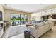 Open-concept living room with tile floors and views of the backyard pool, ideal for entertaining guests at 17914 Howsmoor Pl, Lutz, FL 33559