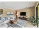 Bright living room with a comfortable sectional sofa, stylish rug, and modern entertainment center at 17914 Howsmoor Pl, Lutz, FL 33559