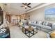 Bright living room with plush seating, a ceiling fan, and natural light streaming in from large windows at 17914 Howsmoor Pl, Lutz, FL 33559