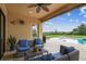 Covered outdoor patio with ceiling fan, outdoor furniture, and views of the pool and backyard at 17914 Howsmoor Pl, Lutz, FL 33559