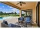 Covered patio with dining and lounge seating overlooking the pool and backyard at 17914 Howsmoor Pl, Lutz, FL 33559