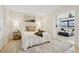 Bright bedroom with white bedding and art; view to sitting room with large sofa at 1960 Kansas Ne Ave, St Petersburg, FL 33703