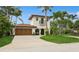 Charming two-story stucco home with a tile roof, arched entry, and lush tropical landscaping at 1960 Kansas Ne Ave, St Petersburg, FL 33703