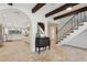 The foyer leads to the kitchen with an open archway and features travertine floors and wooden ceiling beams at 1960 Kansas Ne Ave, St Petersburg, FL 33703