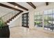 Elegant foyer features travertine floors, an ornate door, a staircase, and a large window with shutters at 1960 Kansas Ne Ave, St Petersburg, FL 33703