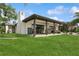 Stunning rear exterior showcasing a covered patio, lush lawn, and beautiful landscaping, perfect for outdoor enjoyment at 1960 Kansas Ne Ave, St Petersburg, FL 33703