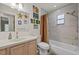 Bathroom featuring a shower-tub combo, neutral tiling, and stylish decor at 1983 Seton Dr, Clearwater, FL 33763