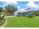 Lovely one-story home with lush green lawn, palm trees, and beautifully landscaped flower beds at 1983 Seton Dr, Clearwater, FL 33763
