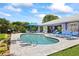 Private backyard oasis featuring a kidney-shaped pool, paver patio, and comfortable lounge furniture at 1983 Seton Dr, Clearwater, FL 33763