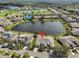 Scenic aerial view of a residential area featuring a lake, manicured lawns, and a beautiful community at 2239 Sifield Greens Way # 84, Sun City Center, FL 33573