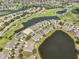 Picturesque aerial view of a community with homes nestled among lakes and a golf course, offering scenic vistas at 2239 Sifield Greens Way # 84, Sun City Center, FL 33573