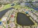 Expansive aerial shot of a lakeside residential community adjacent to a lush golf course and winding water features at 2239 Sifield Greens Way # 84, Sun City Center, FL 33573