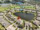 Panoramic aerial view of a residential community surrounding a serene lake and lush landscaping at 2239 Sifield Greens Way # 84, Sun City Center, FL 33573