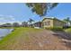 Spacious backyard with a screened-in porch overlooking a serene lake and manicured lawn at 2239 Sifield Greens Way # 84, Sun City Center, FL 33573