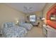 Cozy bedroom features twin beds with floral bedding and a ceiling fan at 2239 Sifield Greens Way # 84, Sun City Center, FL 33573