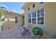 Side view of a home with brick patio, and a chair, showcasing architecture and outdoor space for relaxation at 2239 Sifield Greens Way # 84, Sun City Center, FL 33573