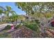 The front yard features mature landscaping and palm trees in front of this lovely home at 2239 Sifield Greens Way # 84, Sun City Center, FL 33573