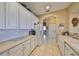 Functional kitchen with white cabinetry, tiled backsplash, and modern appliances with seamless countertops at 2239 Sifield Greens Way # 84, Sun City Center, FL 33573