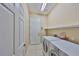 Bright laundry room featuring a washer, dryer, tile flooring, shelving, and a neutral color palette at 2239 Sifield Greens Way # 84, Sun City Center, FL 33573