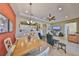 Open-concept living room featuring tile floors, a ceiling fan, and an adjacent kitchen with white cabinets at 2239 Sifield Greens Way # 84, Sun City Center, FL 33573