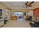 Spacious living room with tile floors, ceiling fan, and sliding glass doors overlooking a picturesque lake at 2239 Sifield Greens Way # 84, Sun City Center, FL 33573