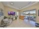 Bright living room with lake views, light tile floors, and access to a screened lanai with seating at 2239 Sifield Greens Way # 84, Sun City Center, FL 33573