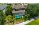 Aerial view of a house with a screened-in pool, surrounded by lush landscaping, and a well-manicured lawn at 23320 Dinhurst Ct, Land O Lakes, FL 34639