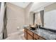 Bathroom with a stylish vessel sink, granite countertops, decorative mirror, and neutral paint at 23320 Dinhurst Ct, Land O Lakes, FL 34639