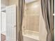 Bathtub with neutral shower curtain, tile surround, shower head, and shower faucet at 23320 Dinhurst Ct, Land O Lakes, FL 34639