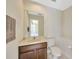 Powder room with a wood vanity and a decorative mirror, offering a functional and stylish space for guests at 23320 Dinhurst Ct, Land O Lakes, FL 34639