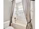 Bathroom with grey tile, grey drapes, shower and tub at 23320 Dinhurst Ct, Land O Lakes, FL 34639
