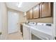 Functional laundry room with sink, storage cabinets, and appliances at 23320 Dinhurst Ct, Land O Lakes, FL 34639